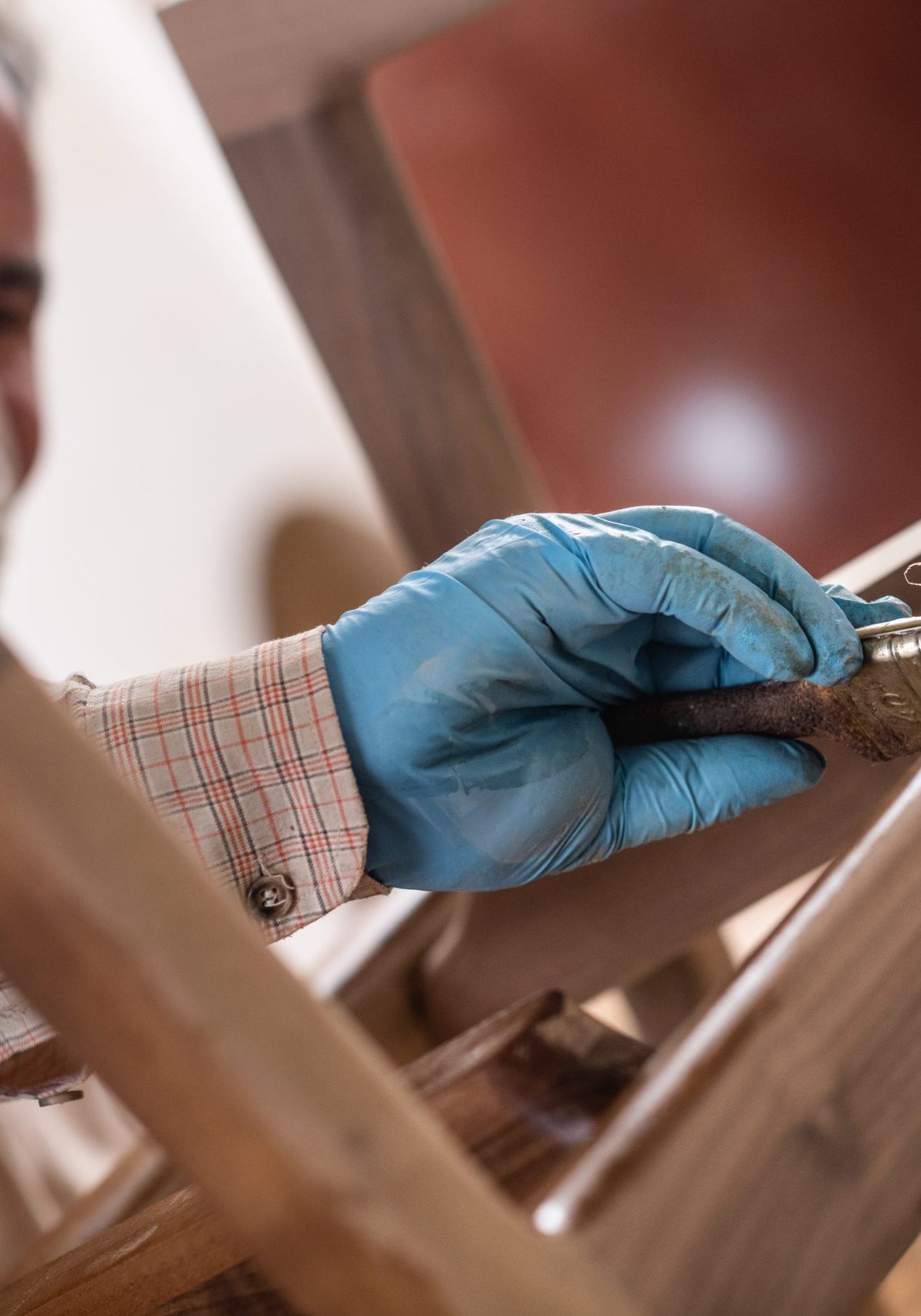 Carpenter applying clear wood stain on furniture